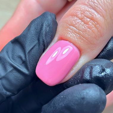 Close-up of a hand with pink nail polish wearing a black glove.
