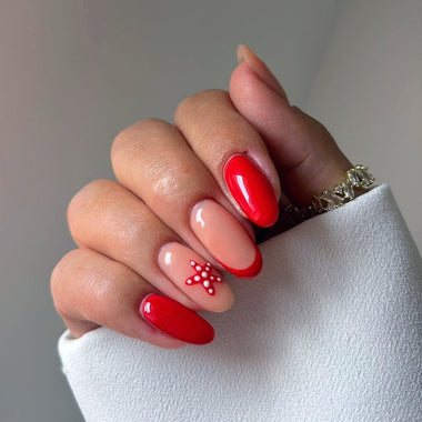 Hand with red and beige nail polish on a neutral background