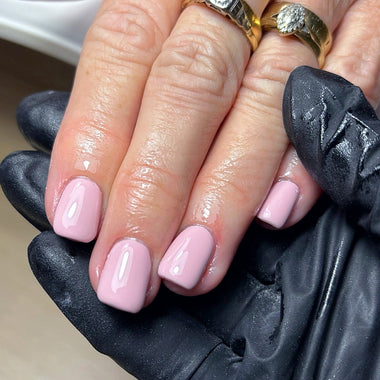 Close-up of hands with pink nail polish wearing a black glove.