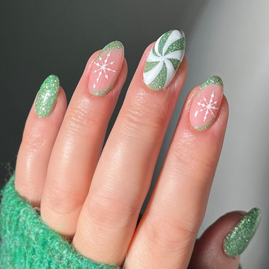 Nail art with green, white, and pink designs on a neutral background