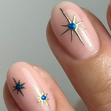 Nails with star-shaped nail art design on a neutral background