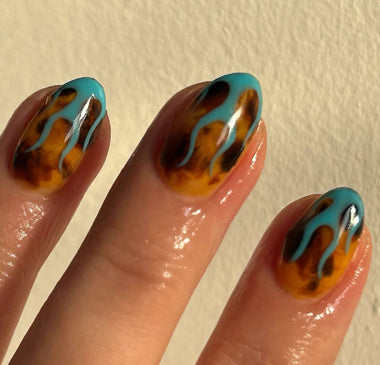 Nails with flame design in blue and brown on a plain background