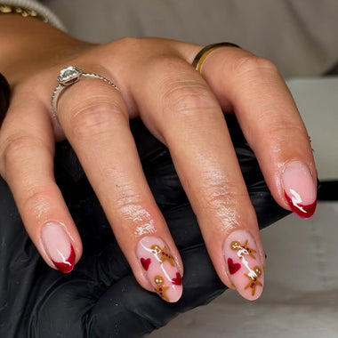 Hand with red and gold nail art holding a phone