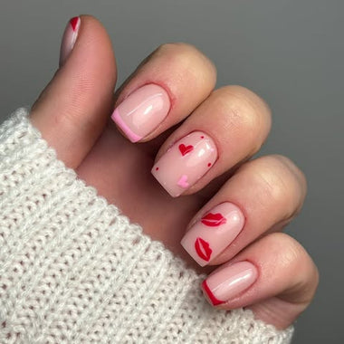 Hand with pink and red nail art on a gray background