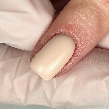 Close-up of a hand with a beige nail on a white background