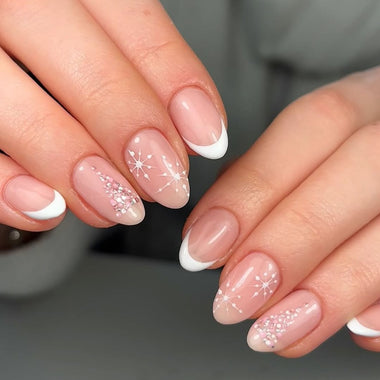 Close-up of hands with pink nail polish and white accents on a dark background
