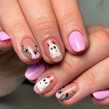 Close-up of hands with pink and white nail art on a neutral background