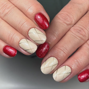 Close-up of hands with red and beige nail polish on a neutral background