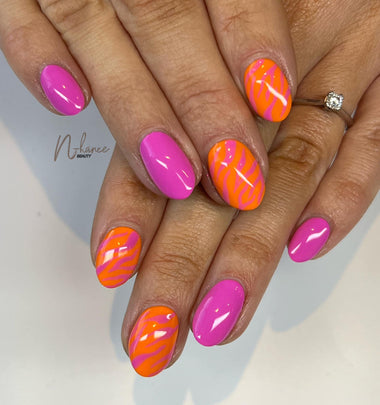 Close-up of hands with pink and orange nail polish on a neutral background