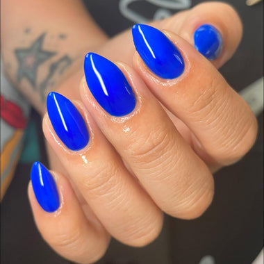 Hand with blue nail polish on a blurred background