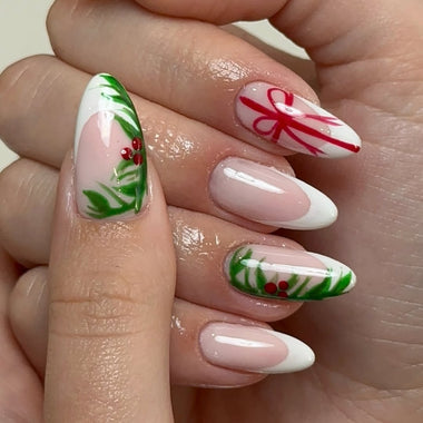 Nails with festive designs including candy canes and bows, held in a hand.