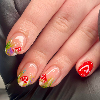 Nails with colorful mushroom design held by a hand