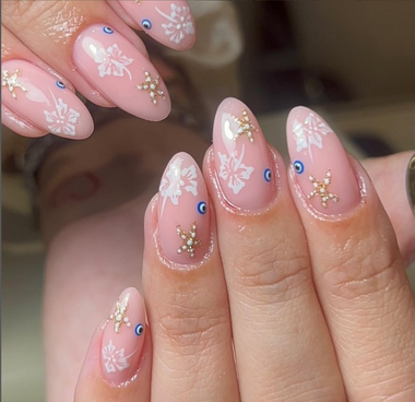 Nails with floral and star designs on a blurred background