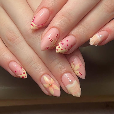 Close-up of hands with pink and red nail art on a neutral background