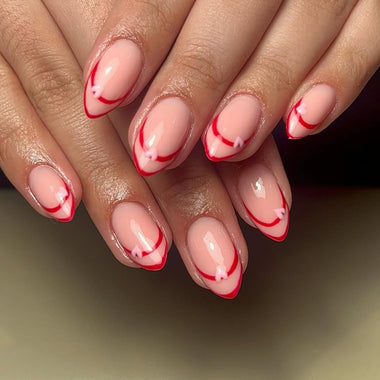 Close-up of hands with pink and red striped nail design on a neutral background
