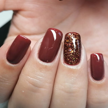 Close-up of a hand with red nail polish on a neutral background