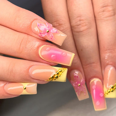 Close-up of hands with pink and gold nail design