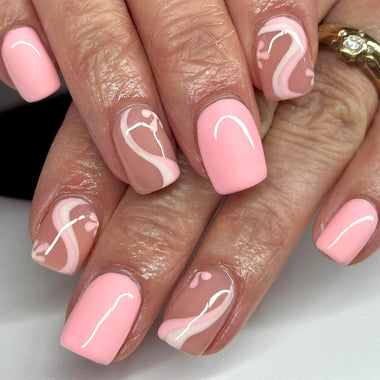Close-up of hands with pink and white nail art on a neutral background