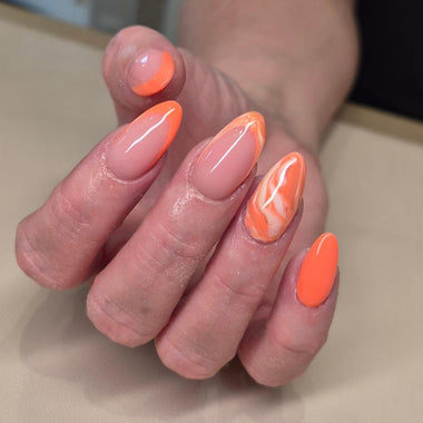 Hand with orange and pink gradient nail polish on a neutral background