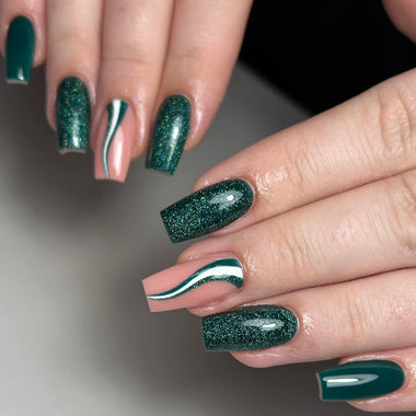Close-up of hands with green glittery nail polish on a neutral background