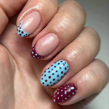 Nails with polka dot design on a neutral background