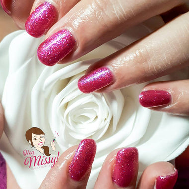 Glittery pink nails painted with the Halo Gel Polish shade 'Cerise Sparkle'