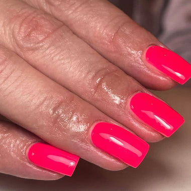 Close-up of a hand with bright pink nail polish on a neutral background