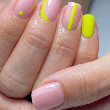 Close-up of a hand with pink and neon yellow nail polish.
