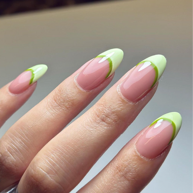 Hand with pink and green nail polish on a neutral background