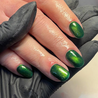 Hand with green glittery nail polish wearing black gloves