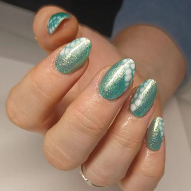 Close-up of a hand with teal and white marbled nail polish on a neutral background