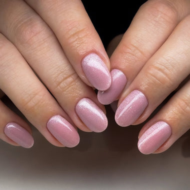 Close-up of hands with pink nail polish on a neutral background