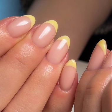 Close-up of a hand with pink and yellow nail polish