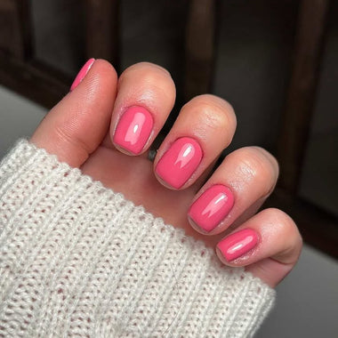 Close-up of a hand with pink nail polish wearing a textured white sleeve.