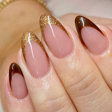 Close-up of a hand with brown and gold gradient nail design