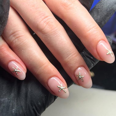 Close-up of a hand with starfish nail art on a neutral background - halo gel polish elise