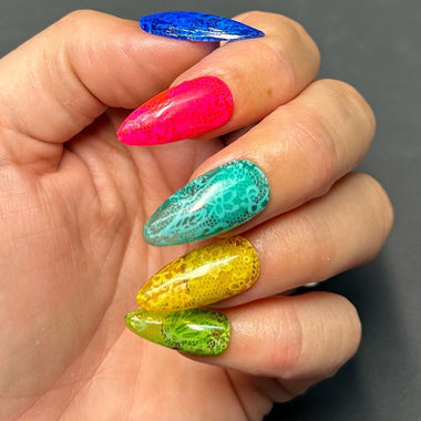 Hand with colorful glittery nail polish on a dark background