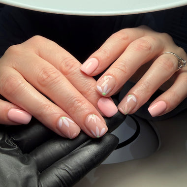 Close-up of hands with pink nail polish and a black glove.