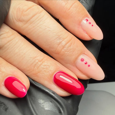 Close-up of a hand with red nail polish on a gray background