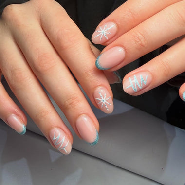 Close-up of hands with decorative nail art on a neutral background