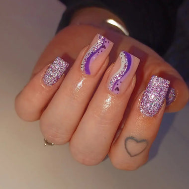 Nail art with purple and pink designs on a neutral background